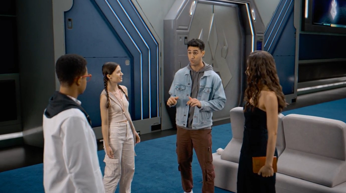 Ahora hay cuatro personajes, un chaval alto y otro con aspecto más intelectual y gafas rojas.