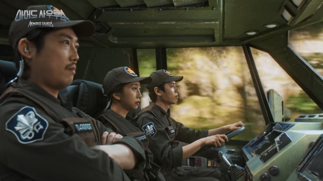 Imagen en la que vemos a tres tipos dentro de un transporte. Las partes transparentes muestran un paisaje moviéndose.