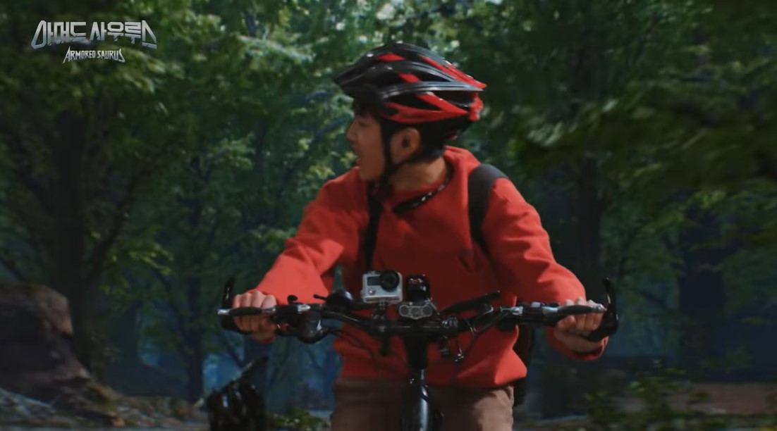 El joven en su bicicleta huyendo de unos raptorbots.