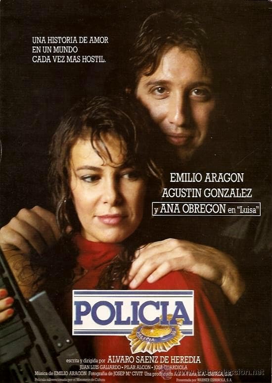 Poster de la famosa película Policía en la que vemos un fondo oscuro, en la parte superior izquierda pone: Una historia de amor en un mundo cada vez más hostil.

En la imagen central tenemos el fondo negro del que sale Emilio Aragón con su pinta habitual de haber dejado de estudiar las oposiciones en la residencia de monjas para irse a tomar una cerveza sin alcohol.  Sus manos agarran los hombros de una Ana Obregón que quizá no esté muy teñida pero que tiene el pelo en modo: Recién salido de la ducha, con un traje rojo, uñas rojas y un fusil entre sus manos. Entre ambos vemos unos letreros: Emilio Aragón, Agustín González y, recuadrado, "y Ana Obregón en "Luisa" ". Sí, dice 'en', no 'cómo'. Yo qué sé.

Debajo el logo, que es el título sobre fondo blanco con barras azules y la placa de la policía, como si fuera aquello el banner de la web de geocities. Y bajo ello los títulos de crédito que destacan que la dirige Álvaro Sáenz de Heredia, probablemente como amenaza.